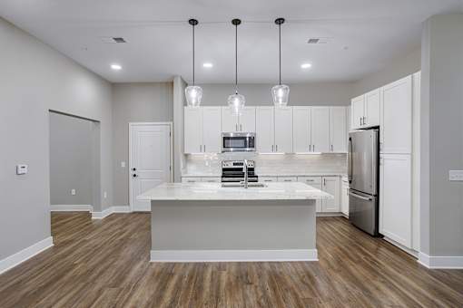 A modern kitchen with a center island and stainless steel appliances.