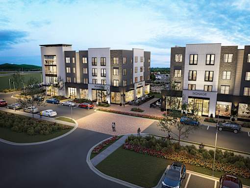 A modern apartment complex with a roundabout in front.