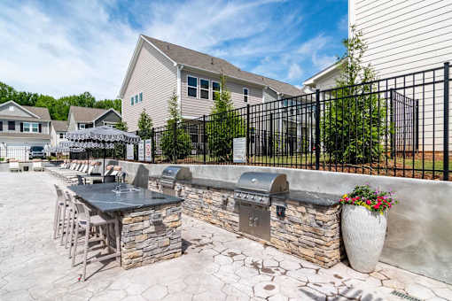 A patio with a table and chairs is surrounded by a black fence.