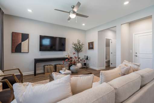 A living room with a white couch and a ceiling fan.