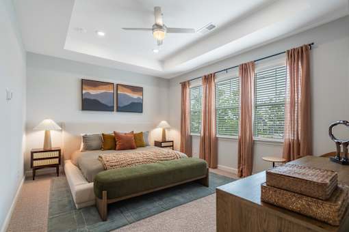 A bedroom with a bed, nightstand, and a painting on the wall.