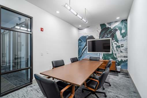 A conference room with a large table and chairs.