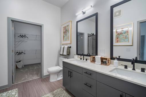 A bathroom with a toilet, sink, and mirror.