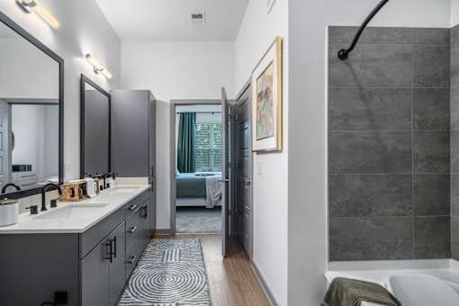 A bathroom with a white sink and a mirror above it.