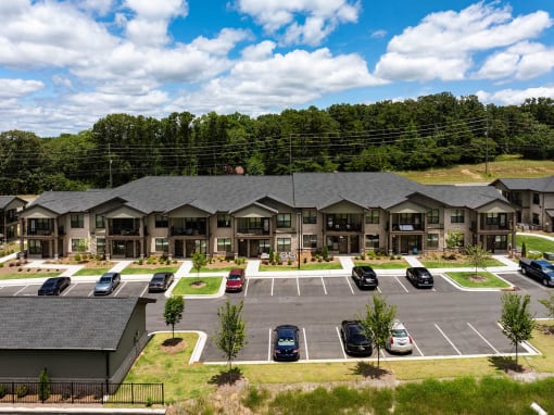 an aerial view of an apartment complex with cars parked in a parking lot
