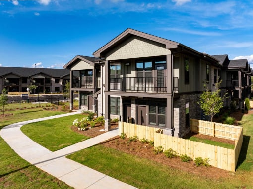 an apartment building with a yard and a sidewalk