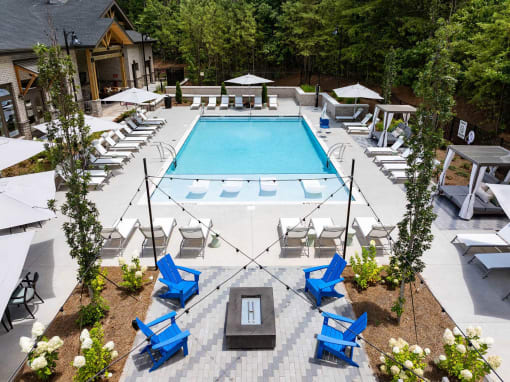 a resort style pool with blue chairs and chairs around it