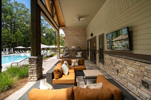 a covered patio with couches and a tv