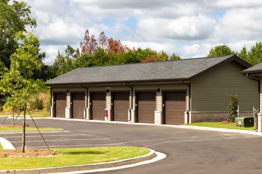 Acworth, GA Apartments - The Brookstone - Parking Lot with Garage and Trees.