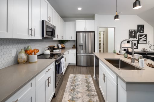 a large kitchen with white cabinets and stainless steel appliances