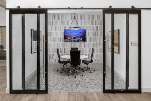 a conference room with a table and a tv on the wall
