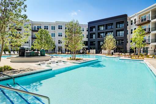 A swimming pool in front of apartment buildings.