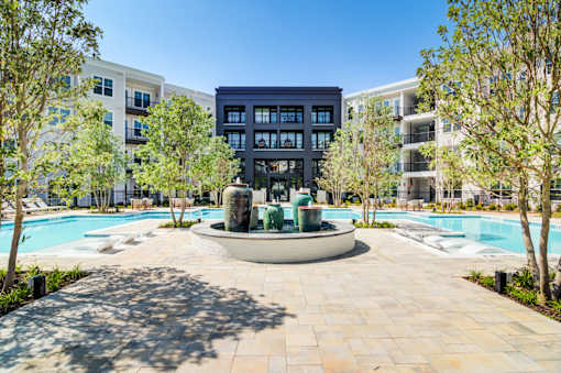 A large building with a pool in front of it.