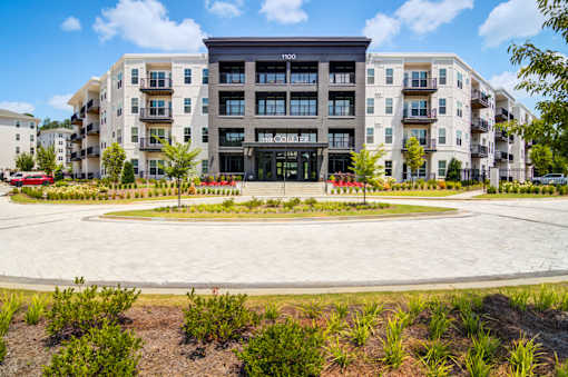 A large building with a black entrance and a sign that says "Inco" is surrounded by other buildings and landscaping.