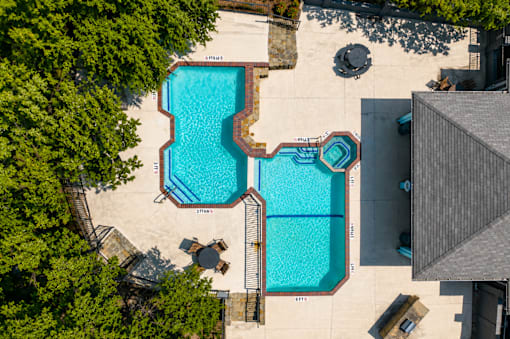 A swimming pool surrounded by trees and a building.