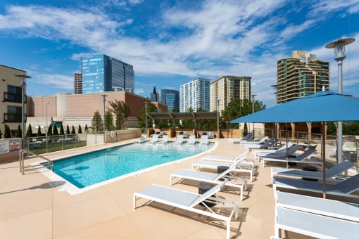 an image of a hotel pool with a city skyline in the background