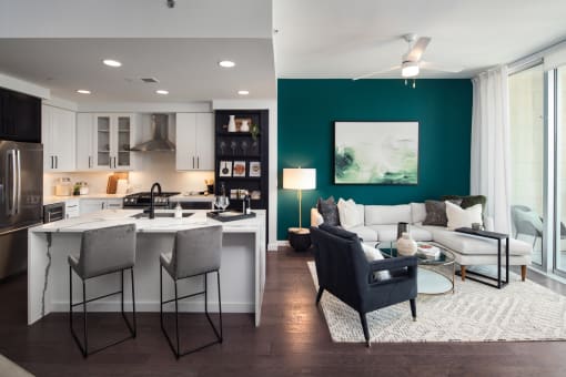 a living room and kitchen with a green accent wall