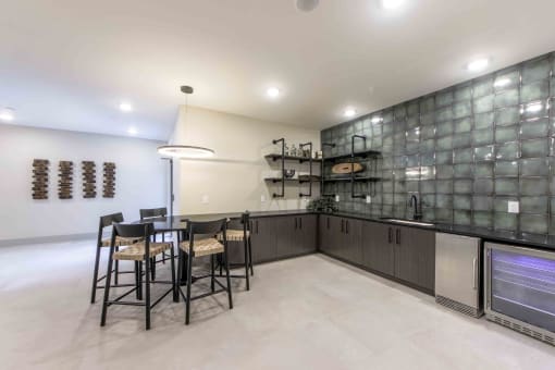 a kitchen with a bar and a table with chairs
