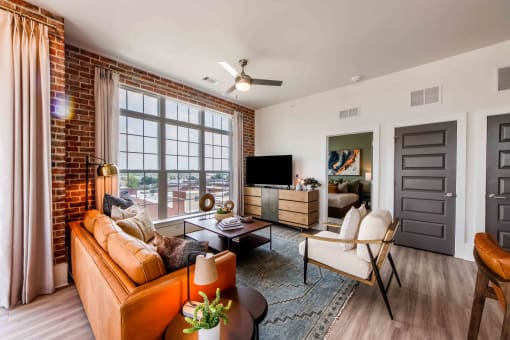 an open living room with a leather couch and a tv