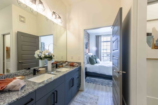 a bathroom with a sink and a door to a bedroom