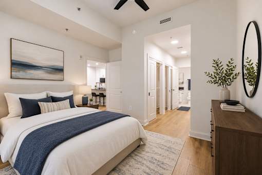 A bedroom with a large bed and a painting on the wall.