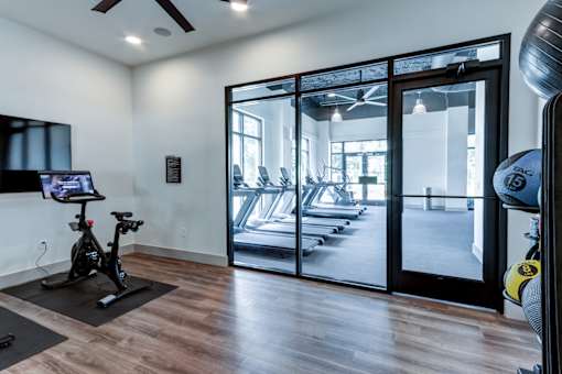 A room with a treadmill and a television.
