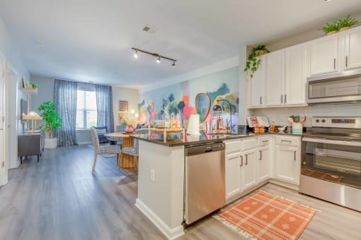 kitchen with white cabinets and stainless steel appliances at the bradley braddock road station apartments