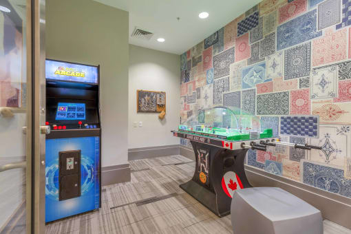 a game room with a foosball table and arcade games
