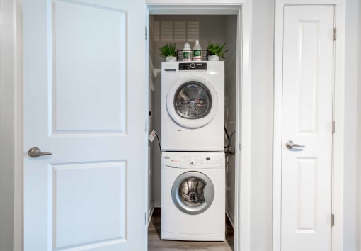 a white washer and dryer in a white laundry room