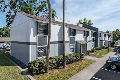 A row of modern townhouses with a clear blue sky above.
