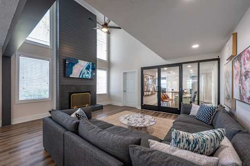 A living room with a grey couch and a fireplace.