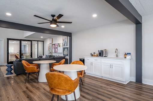 A modern dining room with a white table and orange chairs.