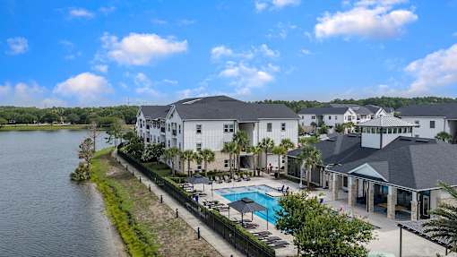A large white building with a pool in front of it.