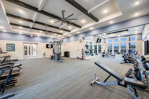 A gym with a variety of equipment including treadmills, weights, and exercise machines.