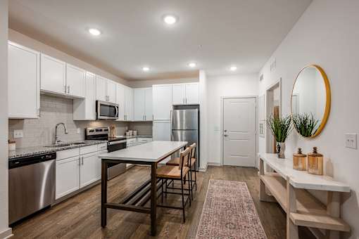 A kitchen with a table and chairs in the middle of it.