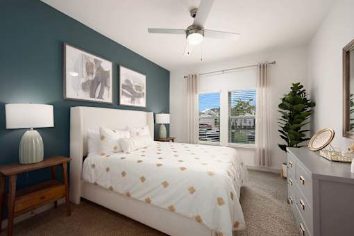 A bedroom with a bed, nightstand, and a ceiling fan.