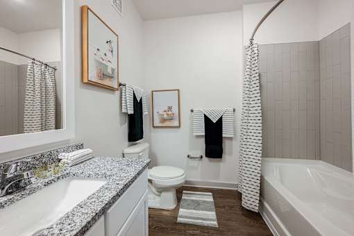 A bathroom with a white tub, toilet, and sink.