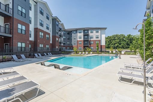 Hermitage Apartments - Expansive Pool And Pool Deck, Lounge Chairs, And Maintained Landscaping. Apartments Are In The Background.