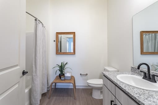 a bathroom with a toilet and a sink and a shower