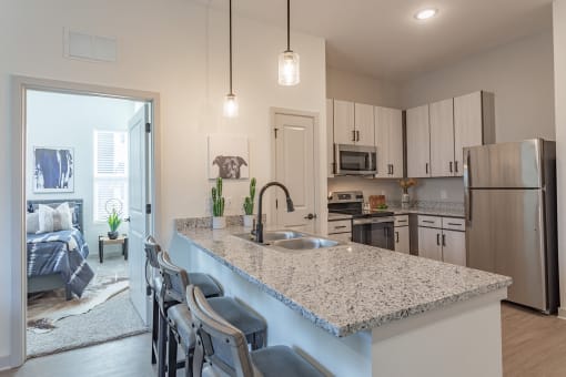an open kitchen and living room with a granite counter top