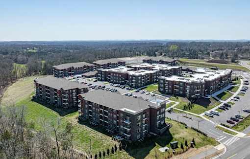 A large, multi-story building complex with a parking lot in front.