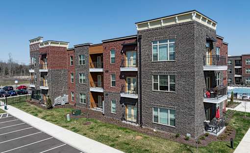 A large apartment complex with a parking lot in front.