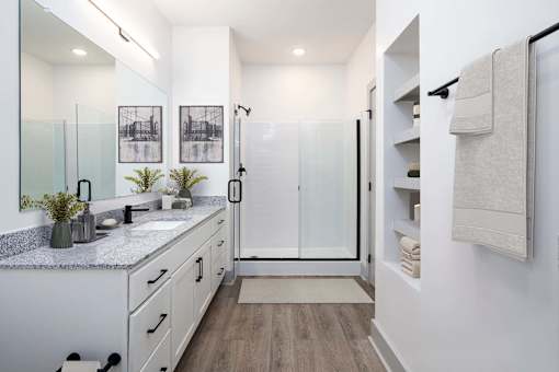 A modern bathroom with a walk-in shower and double sinks.