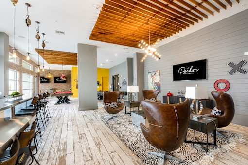 A modern interior with wooden floors and a variety of chairs and tables.