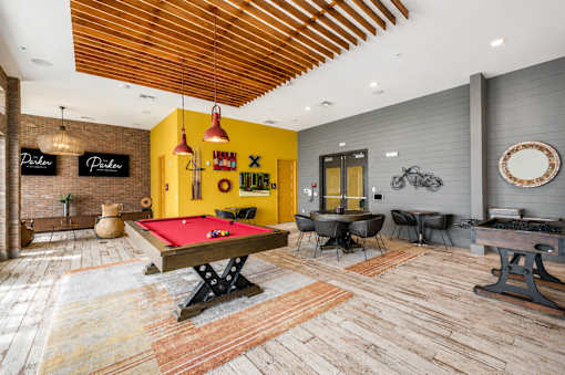 A room with a pool table and a bar area.