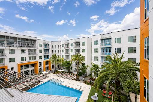 A large apartment complex with a pool in the middle.