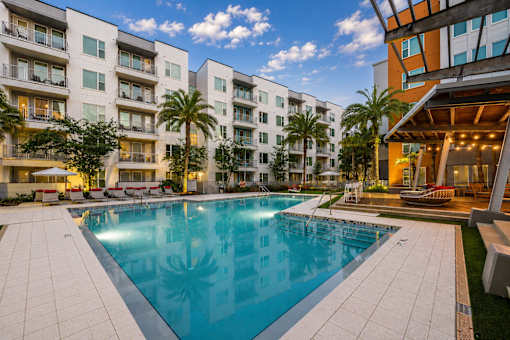 A swimming pool in front of a modern apartment building.