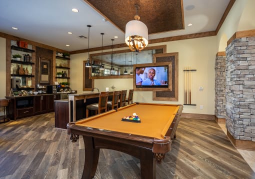 a rec room with a pool table and a tv