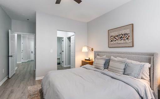 A bedroom with a large bed and a ceiling fan.