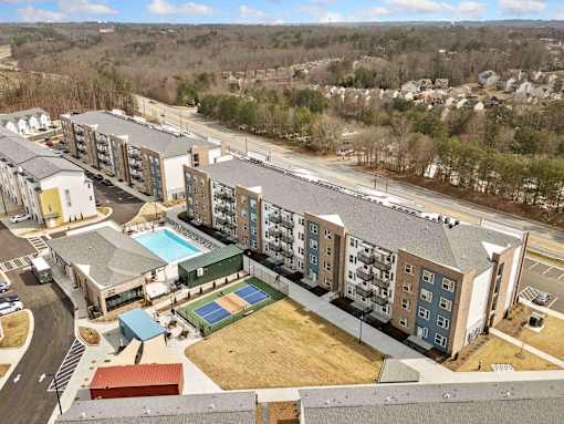 A large apartment complex with a pool and a playground.